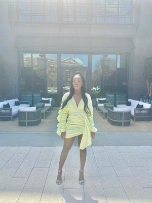 female standing wearing light green mini dress with frills